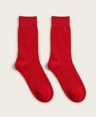 Pair of red socks on a light beige background